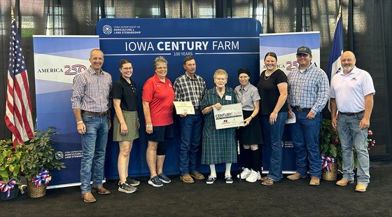 Secretary Naig and IFBF President Brent Johnson present a Century Farm award to a family at the Iowa State Fair.