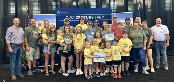 Secretary Naig and IFBF President Brent Johnson present a Century Farm award to a family at the Iowa State Fair.